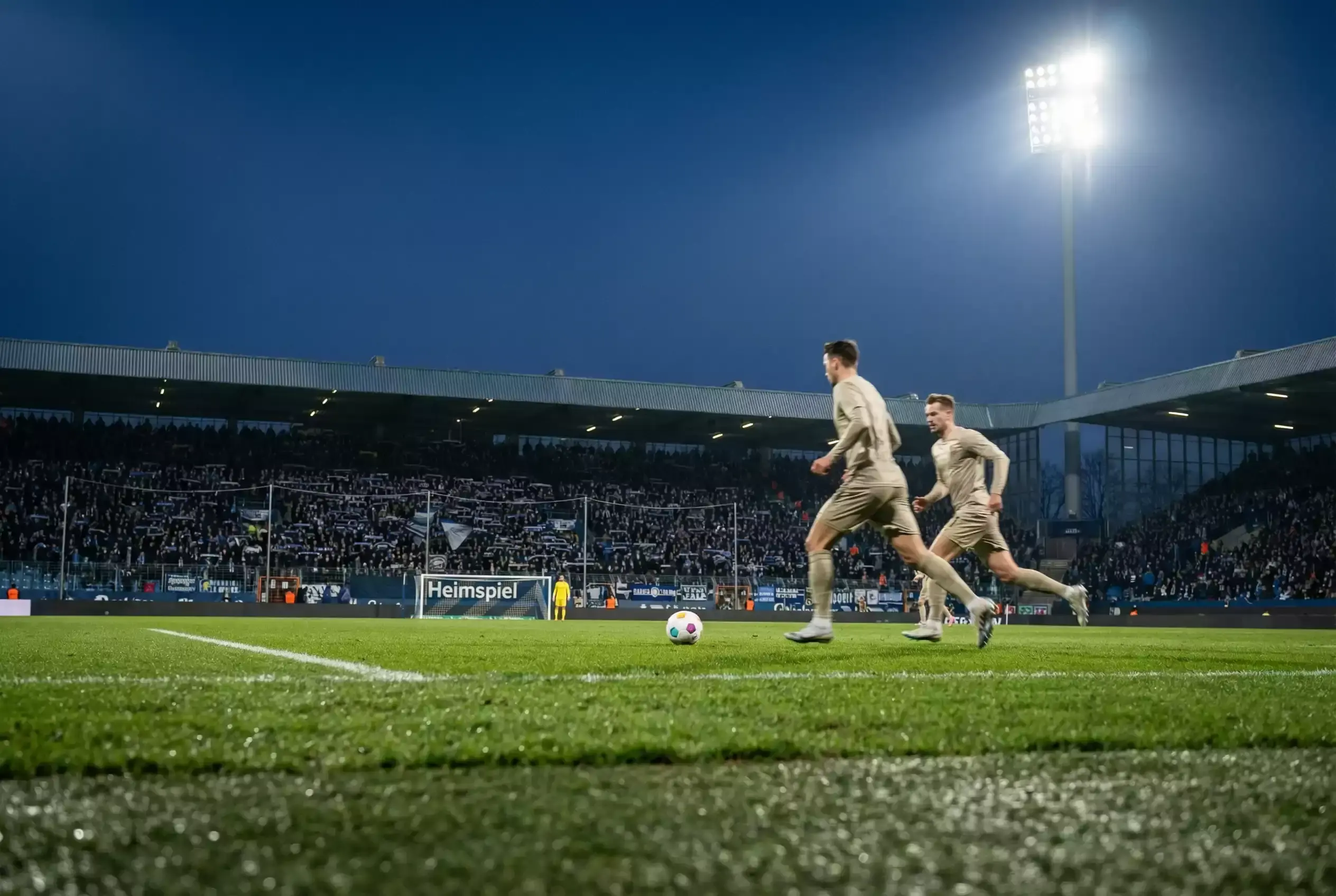 Gefülltes Bundesliga-Stadion bei einem Abendspiel mit Flutlicht
